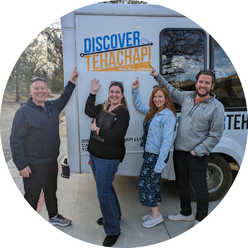 Kristina and friends pointing at the Discover Tehachapi logo on the bus.